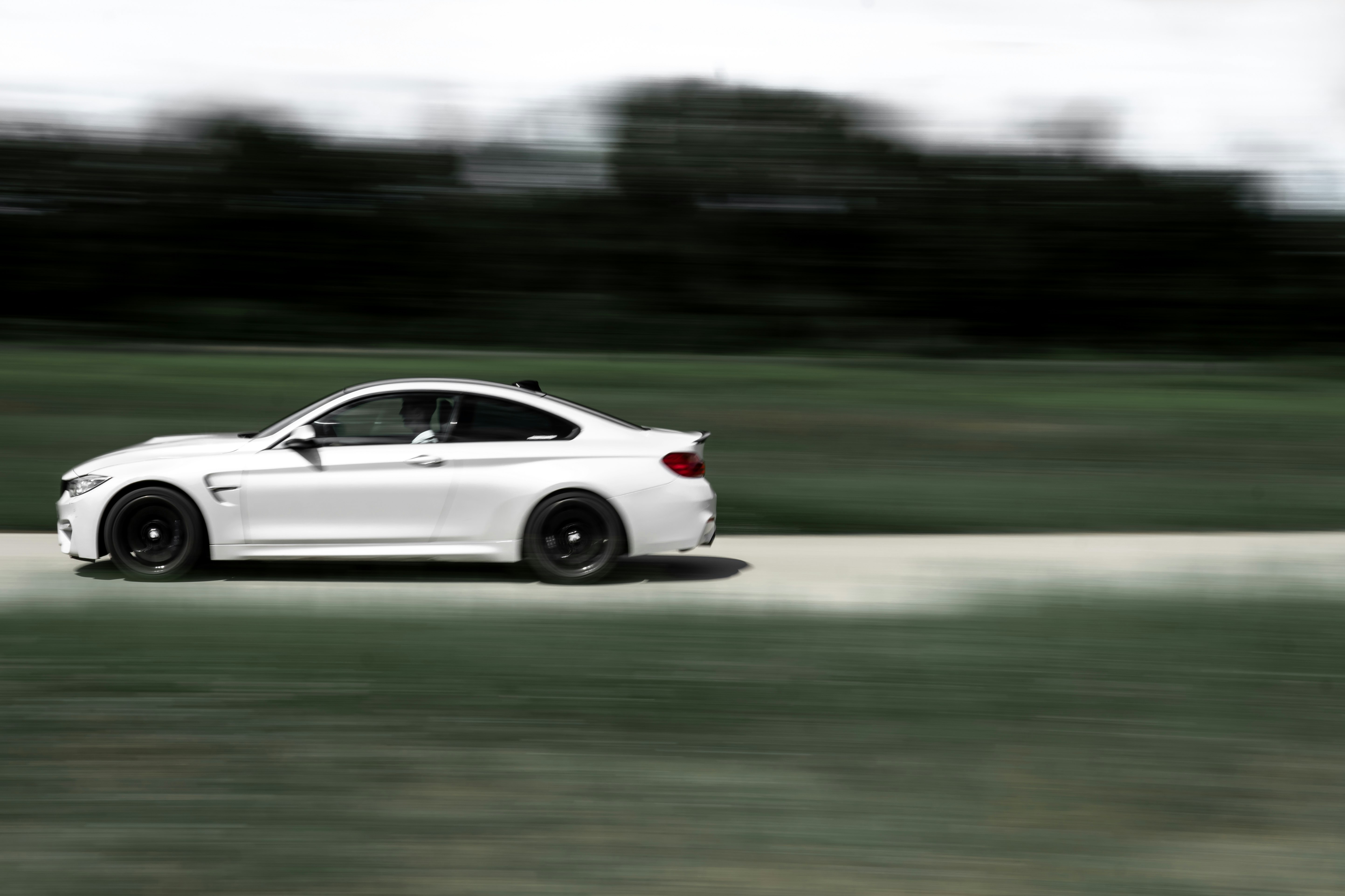 white coupe on road during daytime